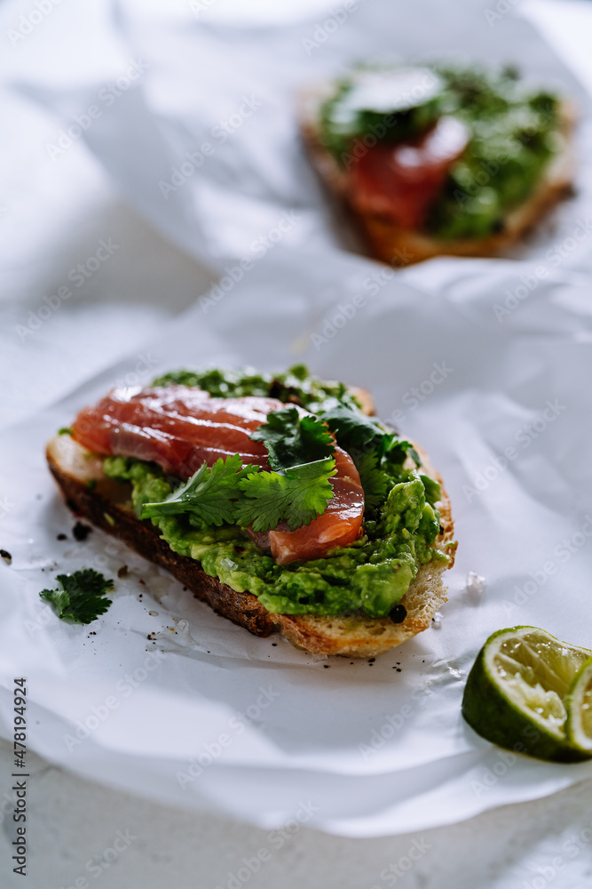 Mashed avocado on toasted bread served with salted salmon Mashed avocado on toasted bread served with salted salmon