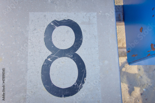Scratched black numbers 8 on a metal surface