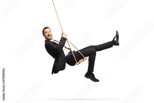 Full length side shot of a happy businessman swinging on a swing