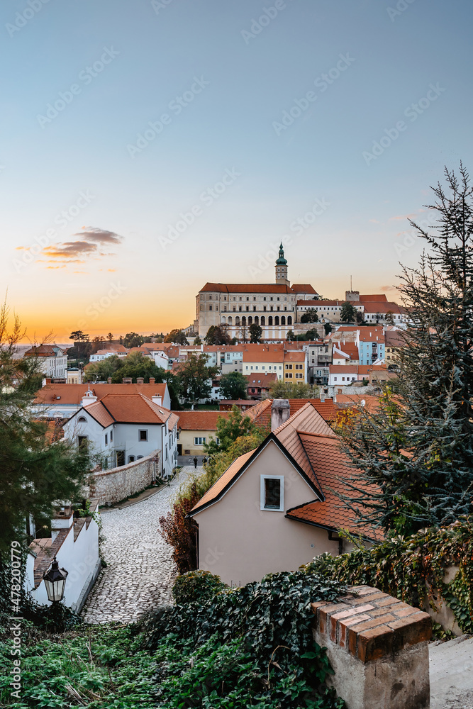 View of Mikulov with beautiful Baroque castle on the rock at sunset,south Moravia,Czech Republic.Dominant of town skyline.Czech Chateau in Palava wine region.Picturesque town among vineyards