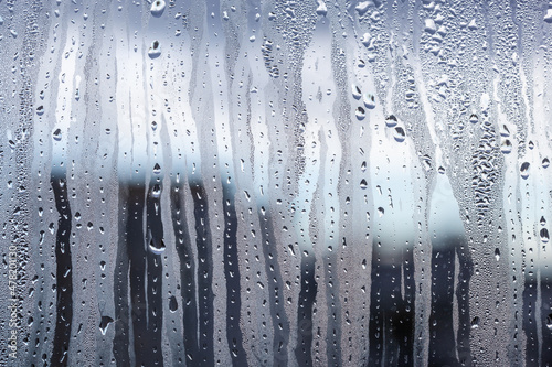 Drops of condensate on the sweaty glass. Cold foggy glass