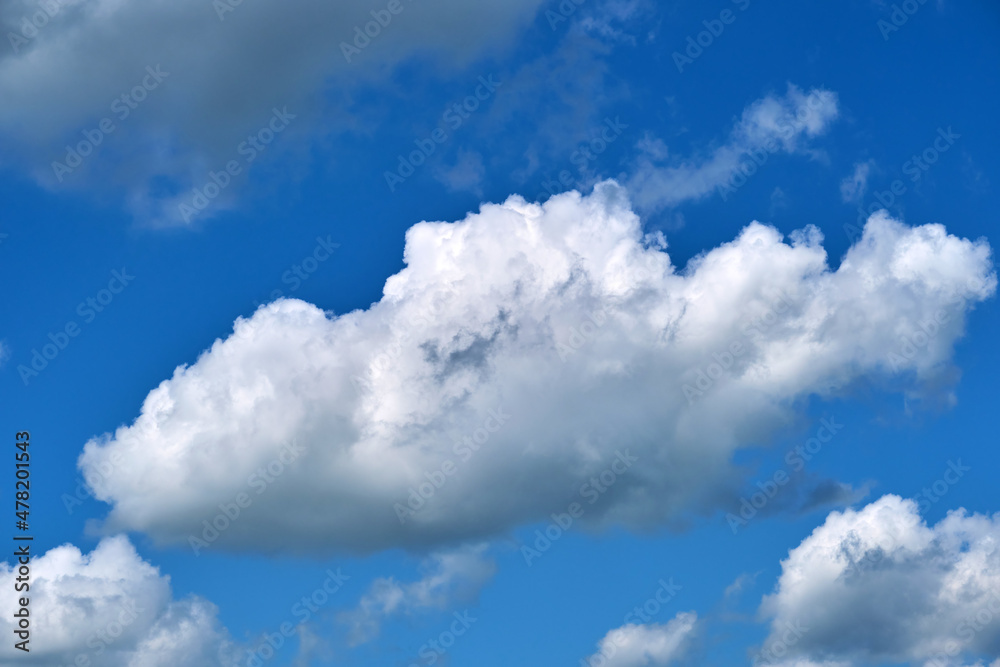 Bright landscape of white puffy cumulus clouds on blue clear sky