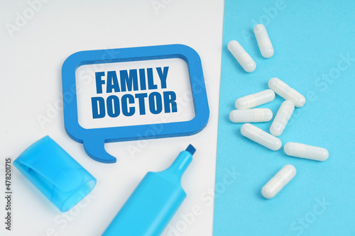 On the white and blue surface are a marker, tablets and a plate inside which the inscription - FAMILY DOCTOR