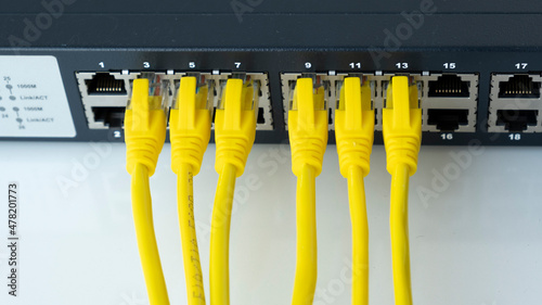 Network switch and six yellow ethernet cable. Network connection technology thrue cat6 and cat5 wires. Network switch and cables. photo