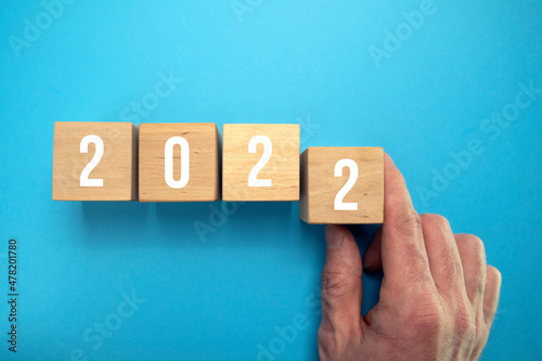 Wooden cubes representing the numbers 2022 isolated on a blue background. New Year's date concept. Wooden cubes with the inscription: 2022. The numbers 2022 are written on the wooden cubes. Copy space