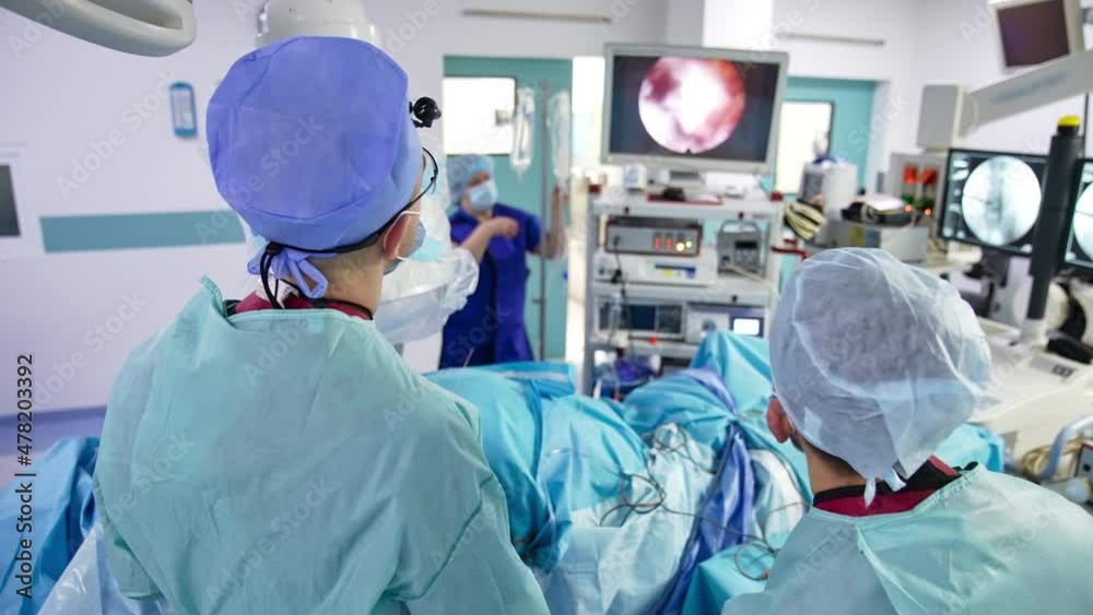 Neurosurgical operation led by a surgeon and his assistant. Modern equipped operation theater in hospital. Innovative surgery apparatuses in blur at the backdrop. Neurosurgical operation led by a surgeon and his assistant. Modern equipped operation theater in hospital. Innovative surgery apparatuses in blur at the backdrop.