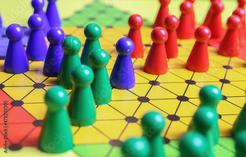 Closeup of gameboard with hexagram, colorful pieces of strategy game sternhalma or chinese checkers - well connected networked concept