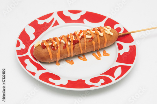 Banderillas o brochetas de salchicha empanizada con harina y servidas con aderezo picante.