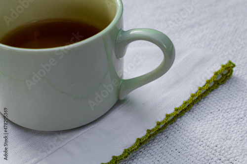 Cup of tea over a white handkerchief. Beautiful cup composition. Background.	
