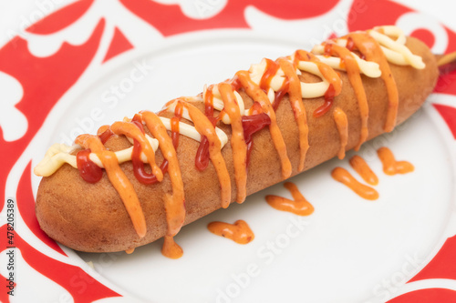 Salchichas empanizadas con mayonesa y ketchup, servidas con aderezo picante