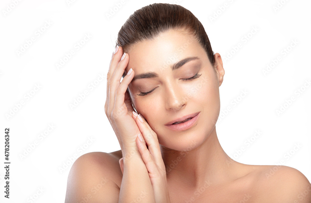 Skin Care Makeup Concept. Natural beauty with perfect skin tone and glowing hydrated makeup. Model woman with natural makeup posing with eyes closed and hands raised gracefully to her cheek Skin Care Makeup Concept. Natural beauty with perfect skin tone and glowing hydrated makeup. Model woman with natural makeup posing with eyes closed and hands raised gracefully to her cheek