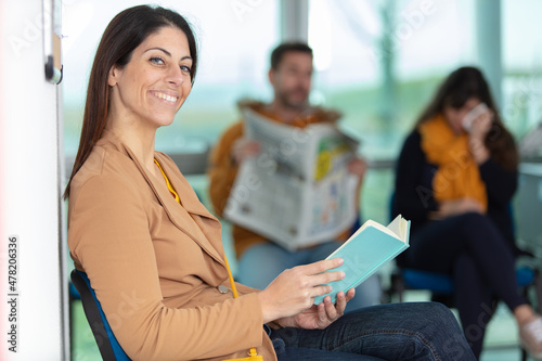 woman reading book in a waiting room