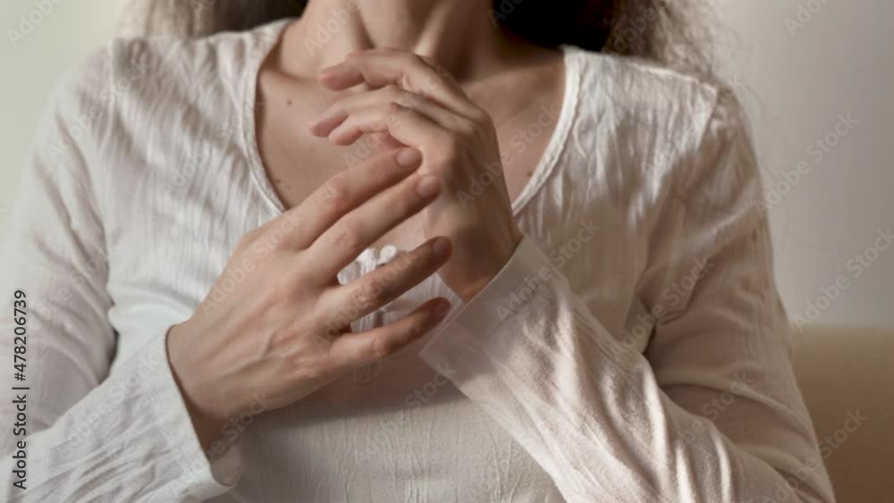 Woman in white shirt practicing EFT - tapping on the side of the hand or karate chop point