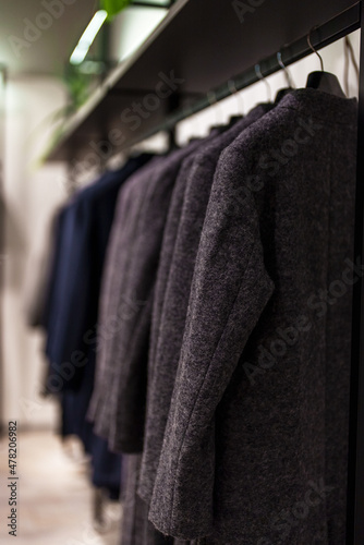 Collection of black drape coat in clothing store.