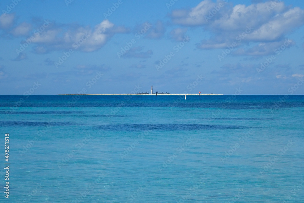  Lighthouse on the horizon, blue ocean and sky with white clouds