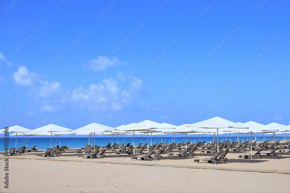 Beautiful tropical  scenery. Loungers, umbrella. Sea. Resort hotel. Rows of folded beach umbrellas and empty sunbeds on the beach. Sea ​​in Turkey. Beach without no tourists because of Covid-19 corona