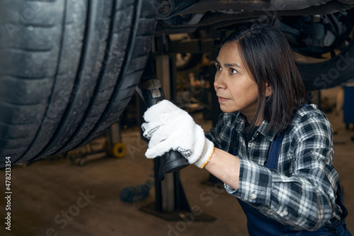 Qualified female mechanic tackling a technical car issue