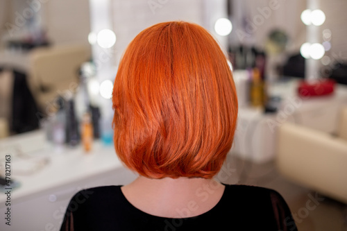 Female back with short, straight, red hair, in hairdressing salon