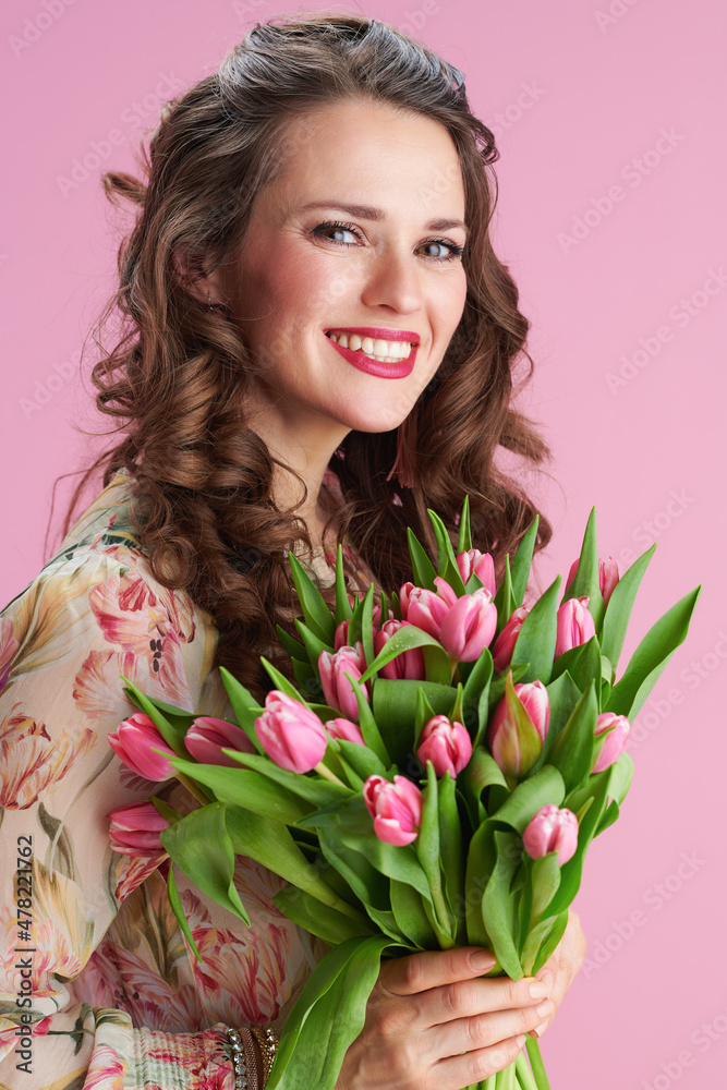Fototapeta premium Portrait of happy woman with long wavy brunette hair on pink