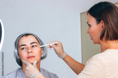 Botox injection into mimic wrinkles on the forehead by a student under the supervision of a master beautician doctor in a cosmetology office. Learning