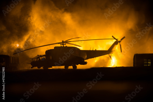 Fotografering Silhouette of military helicopter ready to fly from conflict zone