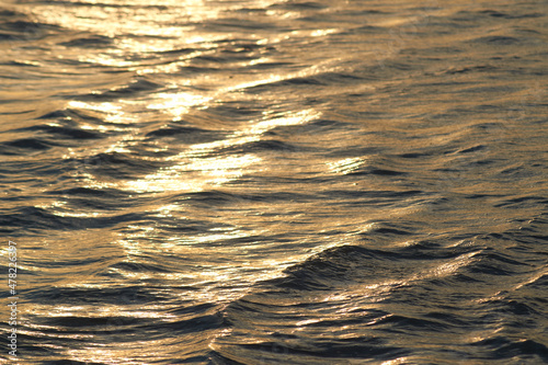 Golden water texture, beach during sunset.