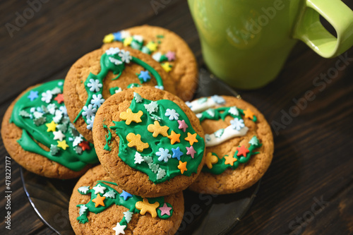 Oatmeal cookies on plate and coffee cup on wooden table, concept of christmas, green color, hommade food, breakfast, biscuit. photo