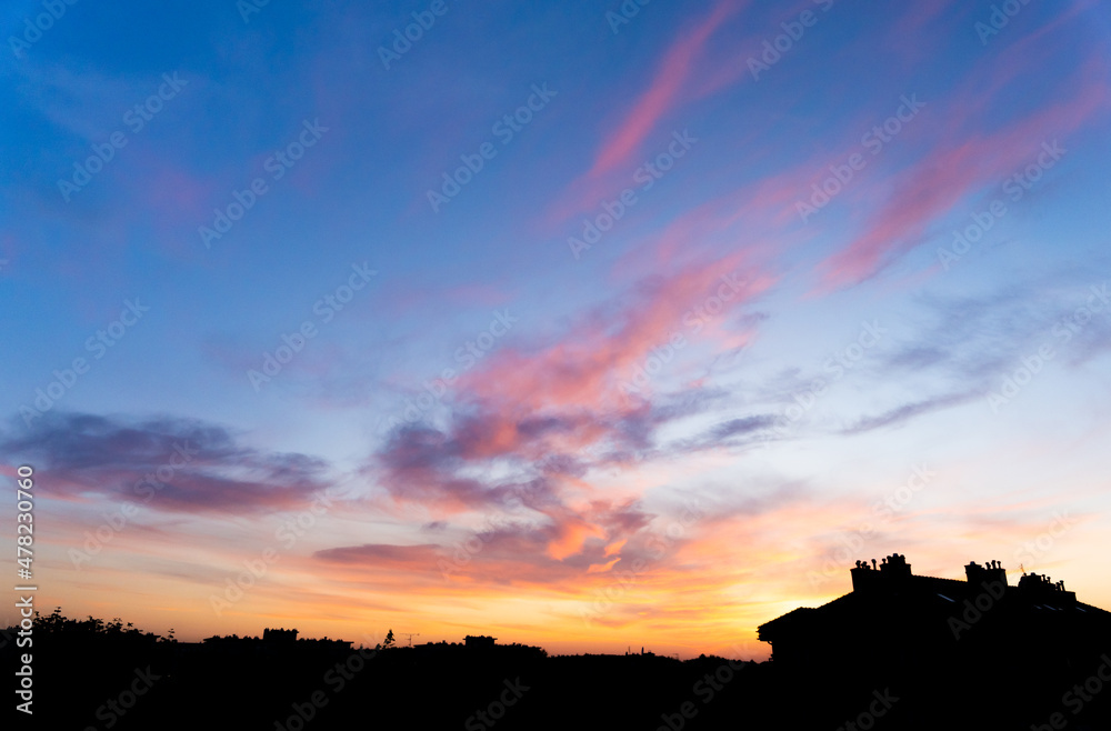 Colorful sky with clouds in the evening. Cloudscape, sunset time. Orange, pink, purple, yellow clouds on blue sky
