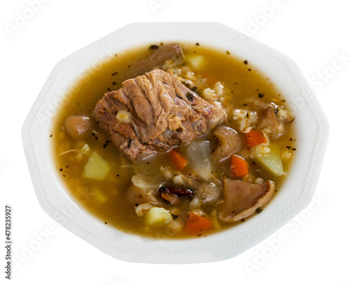Appetizing pork and mushroom soup with vegetables and pearl barley. Comfort food. Isolated over white background.