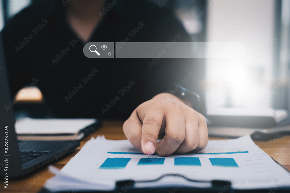 Businessman analyst financial advisor preparing statistical report searching documents on work desk, browsing information online by laptop computer. Businessman analyst financial advisor preparing statistical report searching documents on work desk, browsing information online by laptop computer.