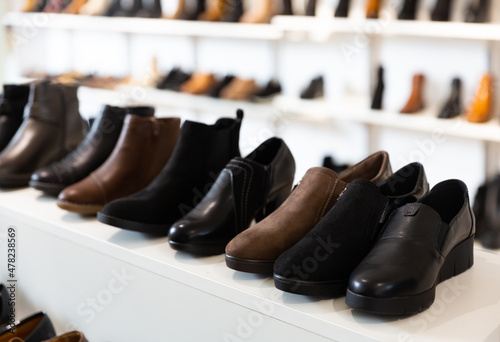 Woman shoes diversity at shelves of apparel shop