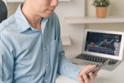 Business man, trader, investor man using smartphone, computer laptop with technical price stock market or Cryptocurrency graph chart for trading, investment on money, Cryptocurrency, stock market.