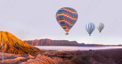 Hot air balloon flying over Mount Bromo volcano viewpoint in Bromo Tengger Semeru National Park at sunrise, Indonesia.