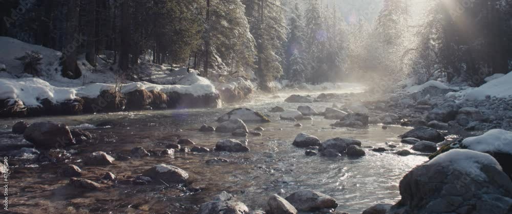 Misty Alps river winter snow evening sun shines riverbed pure water