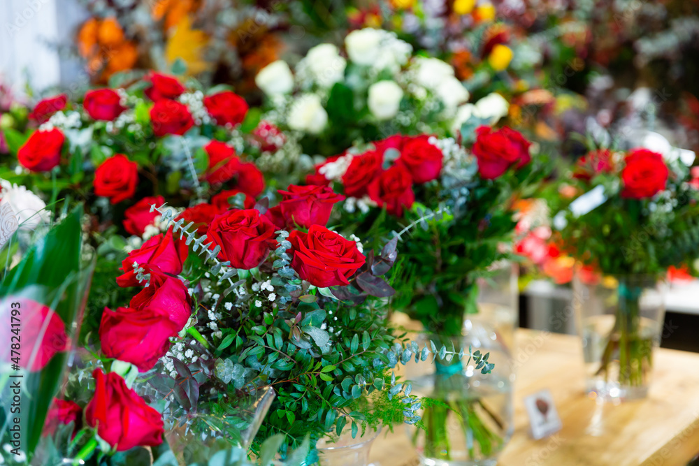 Handcrafted bouquets of flowers placed in salesroom of florist shop.