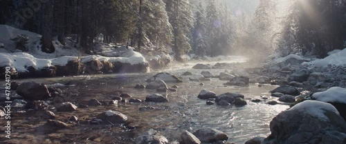 Misty Alps river winter snow evening sun shines riverbed pure water photo
