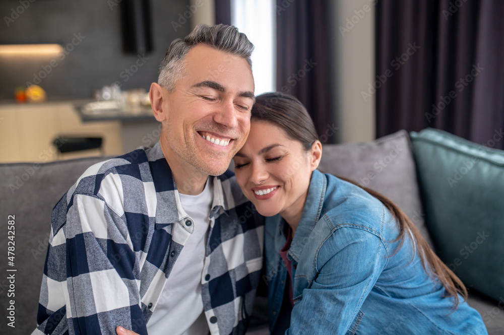 Man and woman embracing sitting on couch