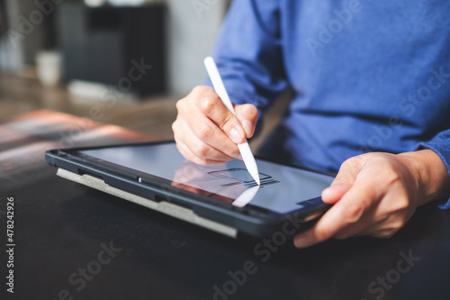 Fototapet Closeup of a woman using smart pen technology for working and writing on digital