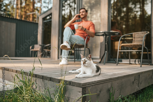 A young man sitting outside and talking on the phone