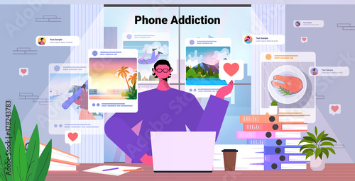 man using laptop at workplace social networks phone addiction concept portrait horizontal