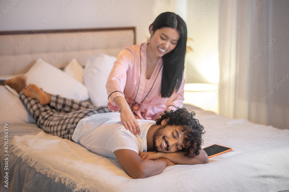 Woman giving back massage to lying man Woman giving back massage to lying man
