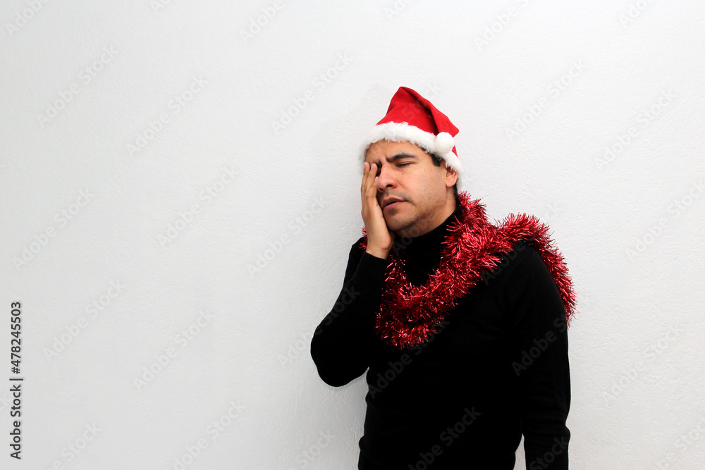 Dark-haired Latin adult man with hat and Christmas garland shows his anger, disgust and sadness for the arrival of December, he does not like Christmas
Dark-haired Latin adult man with hat and Christmas garland shows his anger, disgust and sadness for the arrival of December, he does not like Christmas