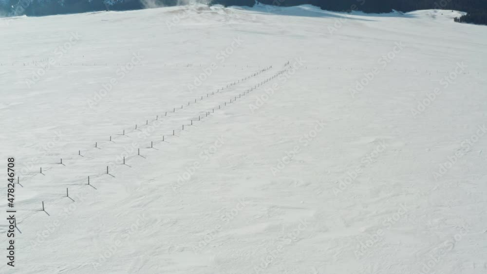 Aerial swoop up to reveal majestic snow alpine mountain next to untouched white snow field. Aerial swoop up to reveal majestic snow alpine mountain next to untouched white snow field.