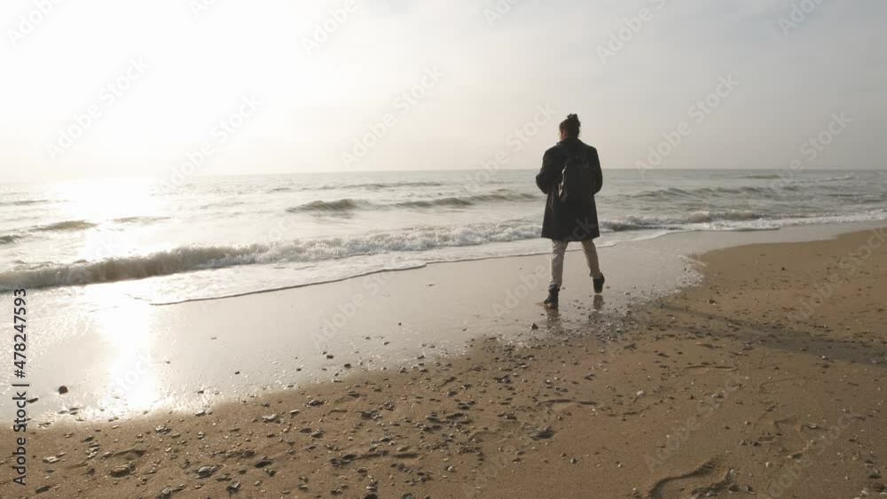 Thoughtful lone man look at sunrise wave ocean horizon and throw stones to water. Thoughtful lone man look at sunrise wave ocean horizon and throw stones to water.