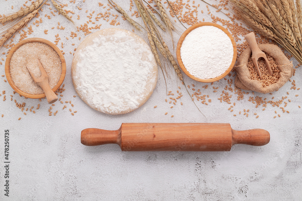 The ingredients for homemade pizza dough with wheat ears ,wheat flour and wheat grains set up on white concrete background. The ingredients for homemade pizza dough with wheat ears ,wheat flour and wheat grains set up on white concrete background.