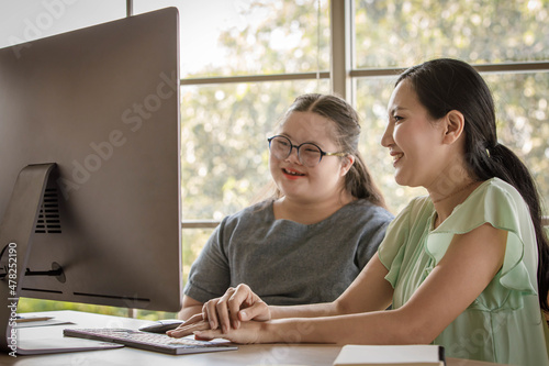Tableau sur toile Portrait shot of Asian happy lovely young chubby down syndrome autistic autism little daughter and mother smiling look at camera while learning online via computer