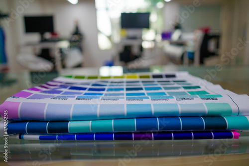 A blurred background photo of the inside of printing room. Color Palette Guide. Sample Colors Catalog. Multicolored bright background. RGB. CMYK. Printing sublimation house. Selective focus. photo
