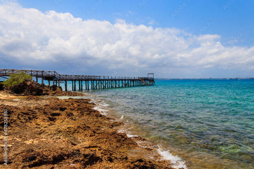 Obraz premium Wooden pier leading to clear blue ocean on Prison island, Zanzibar, Tanzania