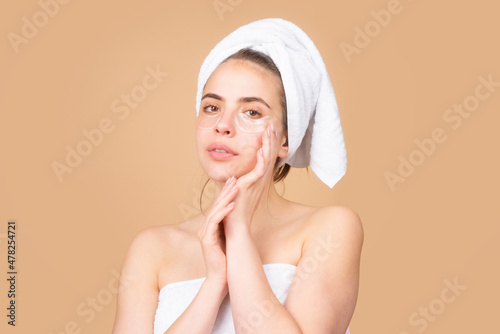 Facial treatment. Cosmetology beauty and spa. Girl apply skincare cream on face, woman wrap towel on head put facial creme on doing morning healthy skin.