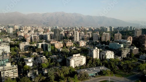 Drone shot in panning of vitacura in santiago de chile with ramon mountain range in the background - aerial view photo